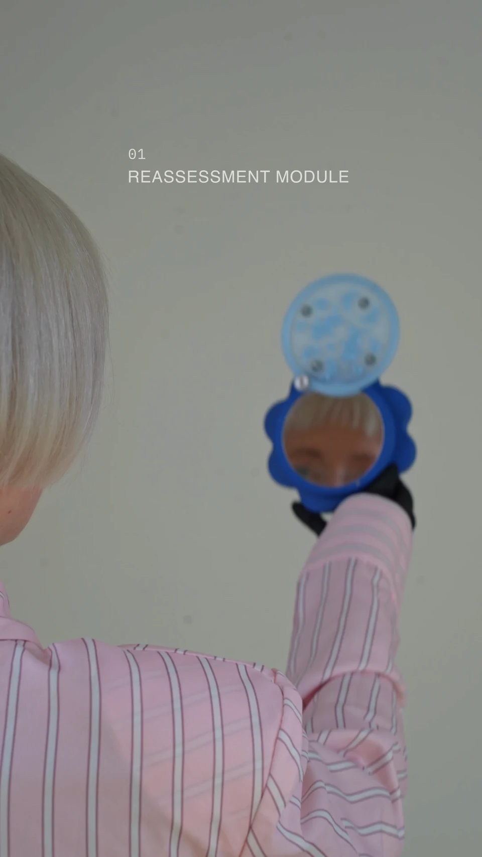 Nadia looking into the opened handheld mirror, with the comb layer visible below.