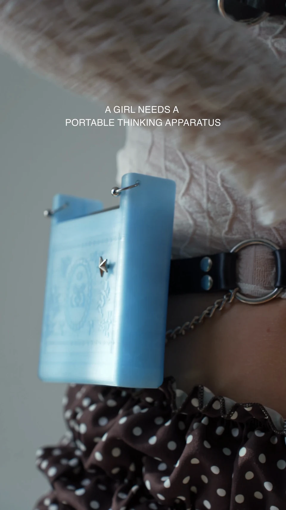 The blue Portable Thinking Apparatus worn at the waist on a leather belt.