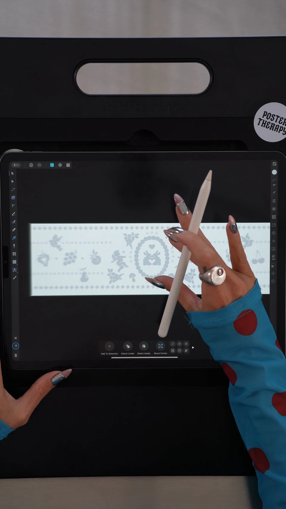 A hand working on a lace motif drawing on a tablet.